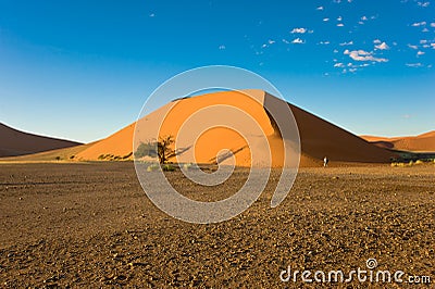 Photographer in front of huge orange dune in Namibia. Dune in Namib Desert, Namibia Stock Photo