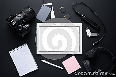 Photographer gadgets. top view of tablet under layout,camera DSLR, wireless headphones, power Bank, notebook, gray card Stock Photo