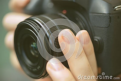 Photographer hands holding a digital camera, focusing and taking photos, macro closeup Stock Photo