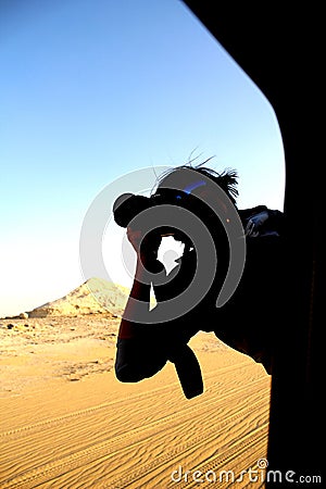 Photographer hanging off car Window taking shot Stock Photo