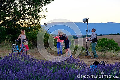 Photographer and lighting assistant taking pictures of a young woman with bicycle Editorial Stock Photo