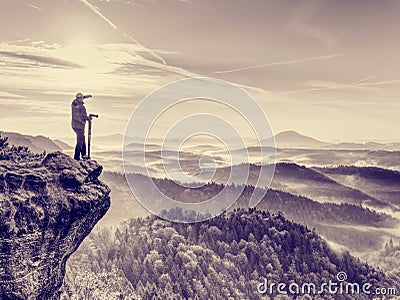 Photographer looks into the landscape and listen the silence. Man prepare camera to takes photos Stock Photo