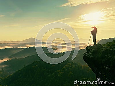 Photographer looks into the landscape and listen the silence. Man prepare camera to takes photos Stock Photo