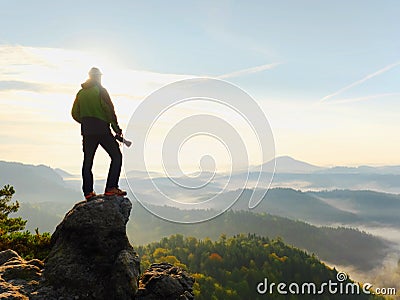 Photographer looks into the landscape and listen the silence. Man prepare camera to takes photos Stock Photo