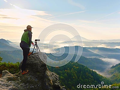 Photographer looks into the landscape and listen the silence. Man prepare camera to takes photos Stock Photo