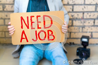 Photographer lost his job. Man holds poster in his hands - Need job. Stock Photo