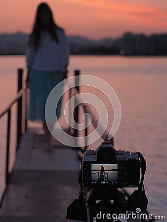 A beautiful sunset, young woman while shooting with beautiful blurred background Stock Photo