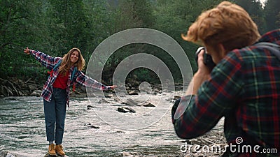Photographer photographing woman at river. Girl making funny grimace at camera Stock Photo