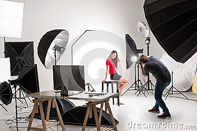 Photographer and pretty model working in modern lighting studio Stock Photo