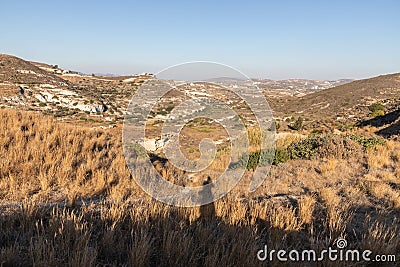 Photographer shadow with Small mountains, valley and typical vegetation in Milos Stock Photo