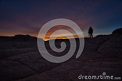 Photographer silhouette as sun rises over White Pocket AZ Editorial Stock Photo