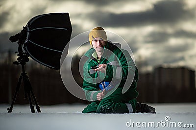 The photographer takes autoportrait remotely on the meadow. Outside Stock Photo