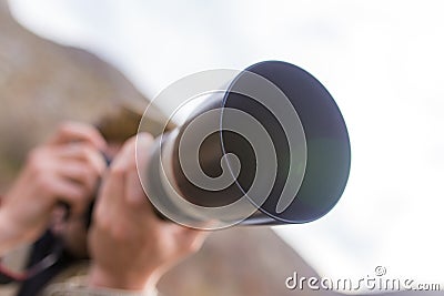 Photographer takes a photo with a large lens Stock Photo