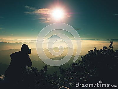 Photographer takes photos with camera on snowy peak Stock Photo