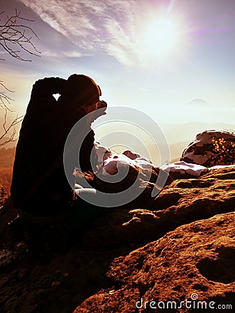 Photographer takes photos with camera on snowy peak Stock Photo