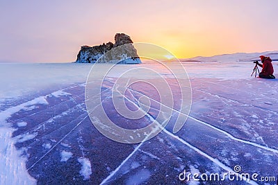 Photographer takes pictures winter ogoy island at sunrise in the ice of Lake Baikal, Russia Stock Photo