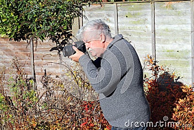 Photographer shooting or taking photograph pointin Stock Photo