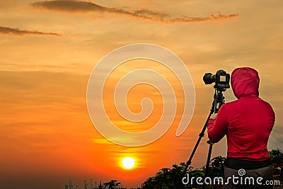 Photographer taking Thailand travel twilight sky photography. Woman photographer shooting with tripod and DSLR camera at sunset w Stock Photo