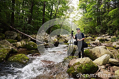 Photographer traveler on a mountain river Stock Photo