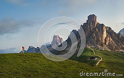 A photographer using a camera making a Beautiful early morning Dolomites Alps mountain landscape photo. Giau Pass or Passo di Giau Stock Photo