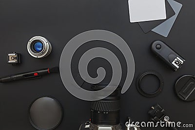 Photographer workplace with dslr camera system, camera cleaning kit, lens and camera accessory on dark black table background. Stock Photo