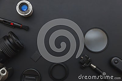 Photographer workplace with dslr camera system, camera cleaning kit, lens and camera accessory on dark black table background. Stock Photo