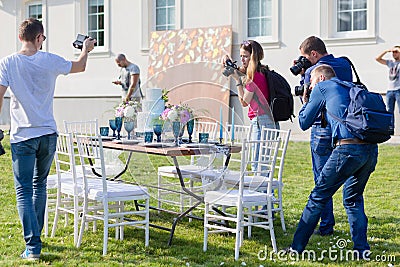 Photographers shoot decorated for wedding elegant dinner table Editorial Stock Photo