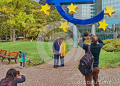 Photographing tourists in front of the euro sculpture in front of the old former building of the European Central Bank ECB Editorial Stock Photo