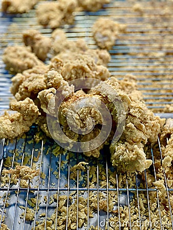 a photography of a bunch of fried food on a rack, doughnuts on a cooling rack on a table with a blue and white plate Stock Photo