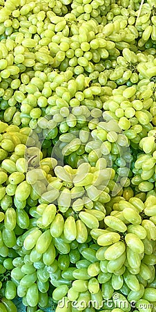a photography of a bunch of grapes are piled together, banana and grapes are piled together in a pile on a table Stock Photo