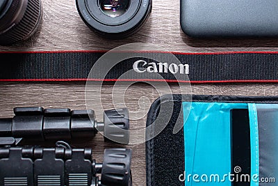 Photography flat lay on a grey wood table. Canon strap in focus Editorial Stock Photo