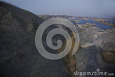 People climbing the rocks and moss on island Editorial Stock Photo