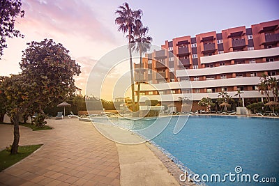 Photography of a residential area during the sunset with palms and pool Stock Photo