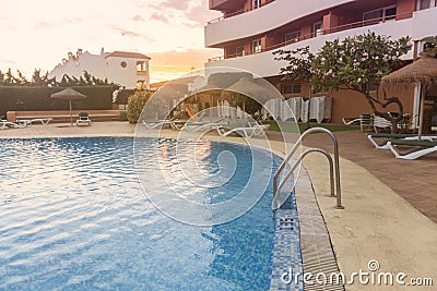 Photography of a residential area during the sunset with palms and pool Stock Photo