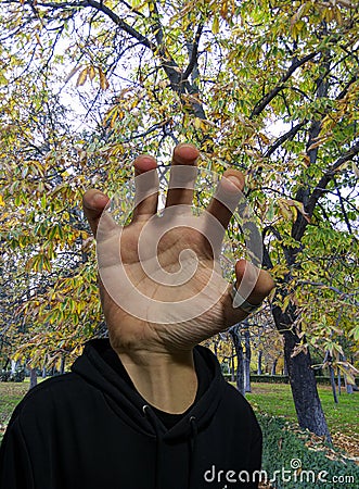 Photomontage of a hand in the position of the head in the middle of an autumnal path in a park in Madrid Stock Photo