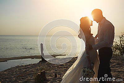 Photoshoot lovers in a wedding dress on the beach near the sea Stock Photo