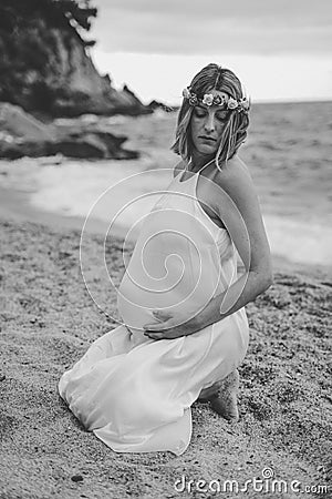 Photoshoot of a pregnant woman walking on the beach Stock Photo