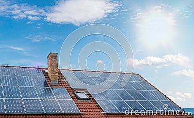 Photovoltaic or solar panels on roof against blue sky Stock Photo