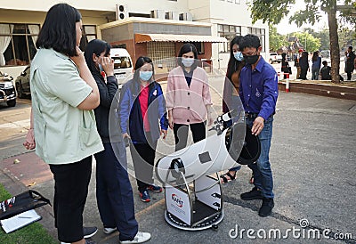 The trainees are studying how to use a reflective telescope with Alt-azimuth mount in an astronomical workshop. Editorial Stock Photo