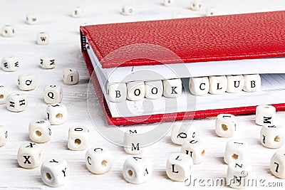 Phrase Book club written in wooden blocks in red notebook on white wooden table. Stock Photo
