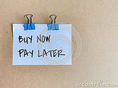 Phrase buy now pay later written on white paper. Stock Photo