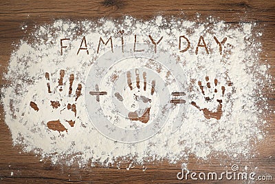 Phrase Family Day and handprints on flour scattered over wooden table, top view Stock Photo