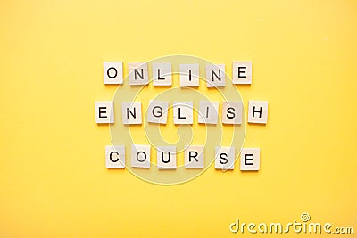 Phrase online english course made from wooden blocks on a light yellow background Stock Photo