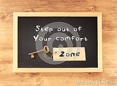 The phrase step out of your comfort zone written on blackboard Stock Photo