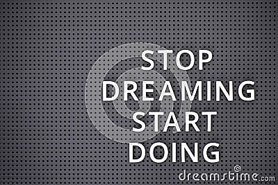 Phrase Stop Dreaming Start Doing spelled out with white letters on gray pegboard Stock Photo