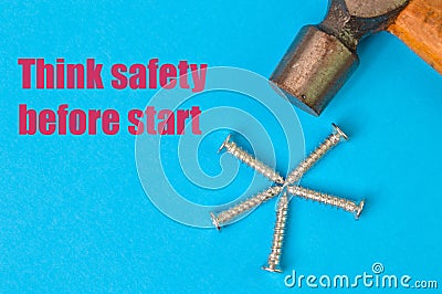 Phrase THINK SAFETY BEFORE STARTED written on a blue background with hammer and bunch of screws Stock Photo