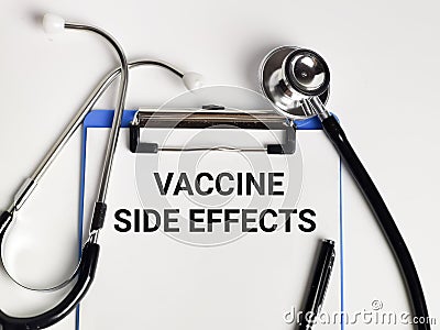 Phrase VACCINE SIDE EFFECTS written on paper clipboard with stethoscope and a pen. Stock Photo