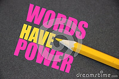 The phrase Words Have Power written with yellow pencil on texturized dark grey paper. Copywriting PR publishing business concept Stock Photo