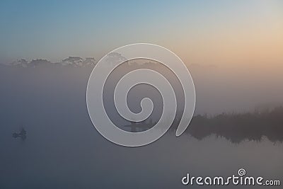 Sunrise and silhouette of pine tree at water pond on the mountain top of Phu Kradueng National Park Stock Photo