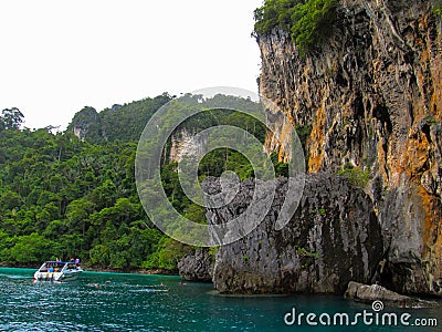 Phuket, Phuket Thailand - 10 15 2012: small boat with tourists stopped near a huge rock so that tourists could understand the Editorial Stock Photo